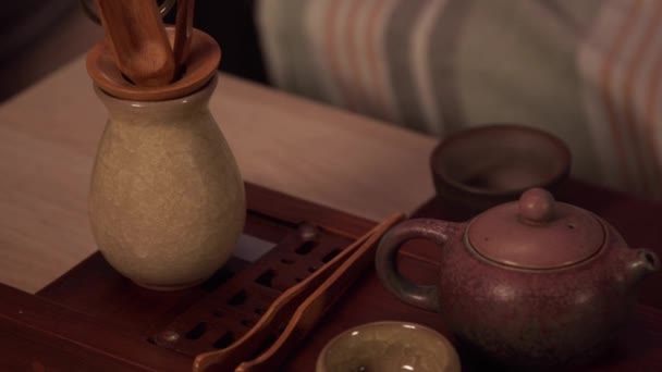 Panoramatický záběr na čajový obřad. Plnou sadu nádobí. Šálky, misky, konvice z Yixingské hlíny, kleštičky na čaj a sušené čajové lístky v misce. Zpomalení. - Záběry, video