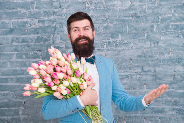 Spring everywhere. Womens day. Flower for March 8. Spring gift. Bearded man hipster love flowers. Bearded man with tulip bouquet. Love date. international holiday. Love spring. Love is in the air - Foto, afbeelding