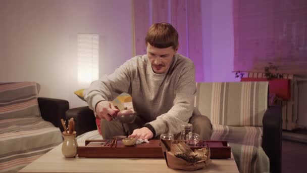 Mężczyzna wyciera krople rozlanej chińskiej herbaty ze stołu po zakończeniu domowej ceremonii herbaty. - Materiał filmowy, wideo