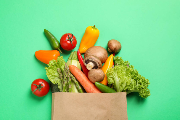 Different fresh vegetables on green background, flat lay - Fotó, kép
