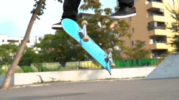 ÁNGULO BAJO: Skateboarder masculino hace un giro fresco 360 mientras que monta alrededor del parque. - Metraje, vídeo