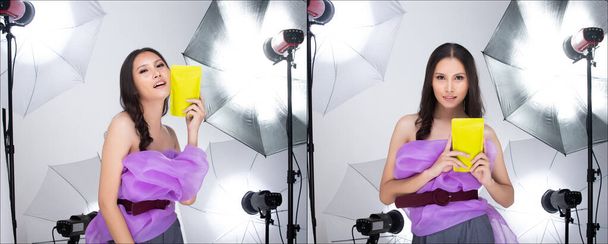 Азійська жінка в пурпуровому одязі, показує зелений пакет, який має порожній зелений простір для реклами, в студії з парасольковим фоновим копіювальним простором - Фото, зображення