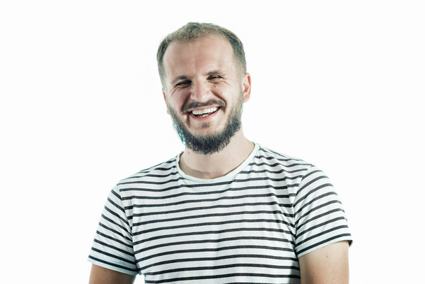 Homme adulte barbu riant en T-shirt rayé. 30-35 ans. Isolé sur blanc - Photo, image