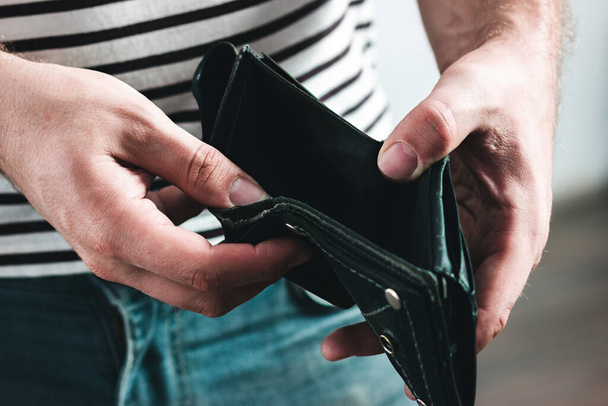 Prázdná peněženka v mužských rukou jako symbol finanční krize a špatné ekonomiky - Fotografie, Obrázek