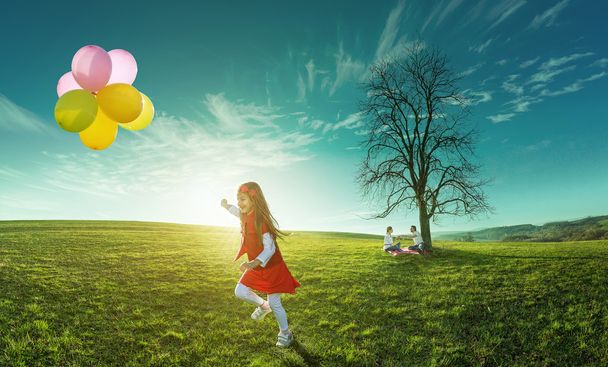 Fille heureuse courant dans une prairie avec des ballons colorés
 - Photo, image