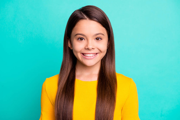 Portrait of small kid girl look in camera toothy smiling wear yellow shirt isolated over teal color background - Φωτογραφία, εικόνα