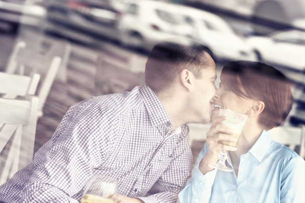 Young couple kissing in a restaurant - Φωτογραφία, εικόνα