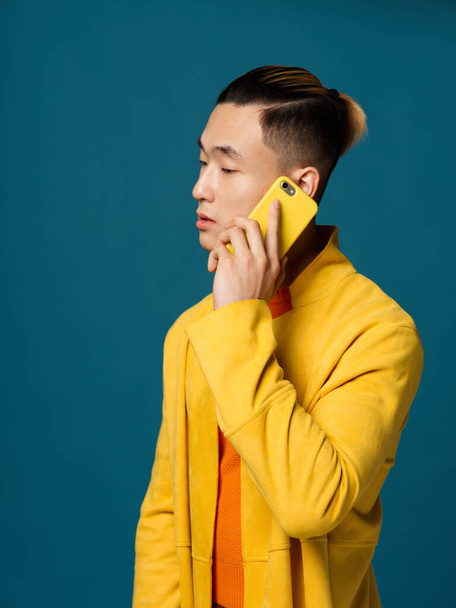 Auto mluví po telefonu a ta asijsky vyhlížející žlutá bunda - Fotografie, Obrázek
