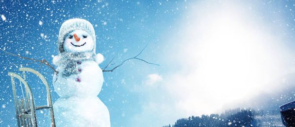Boldog hóember áll a téli karácsonyi táj. - Fotó, kép