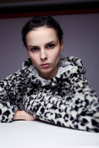 woman in a sweatshirt with a hood, light background - Foto, Imagem