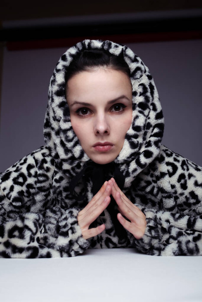 woman in a sweatshirt with a hood, light background - Fotografie, Obrázek
