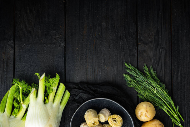 Zutat Kartoffel und Artischocke al forno, auf schwarzem Holztisch, von oben mit Platz für Text - Foto, Bild