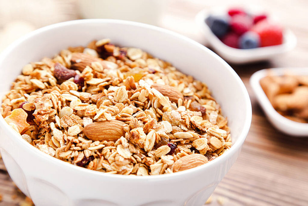 Tasty granola in bowl on brown wooden background - Foto, immagini