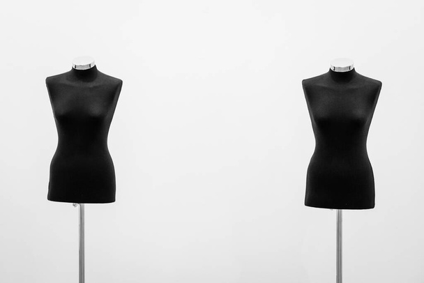 Two Mannequins without head or limbs, black, with a white wall in the background. - Photo, Image