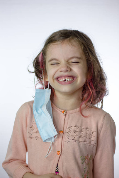 Маленька дівчинка з маскою на вухо сміється
 - Фото, зображення