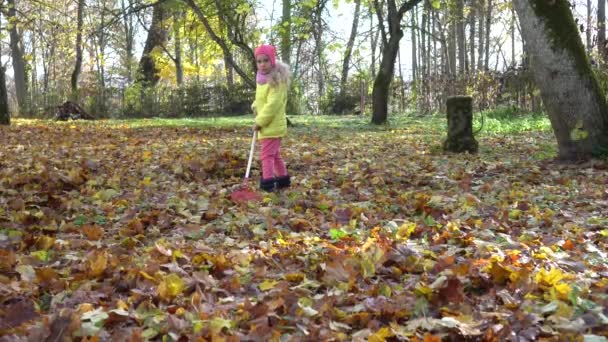 Verrücktes Kindermädchen kämpft gegen bunte Herbstblätter im Hinterhof des Hauses. - Filmmaterial, Video