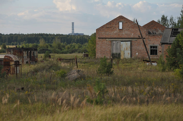 Verlaten boerderij en radioactief kerkhof in de buurt van dorp Kopachi, postapocalyptisch uitzicht op kerncentrale, verboden gebied Tsjernobyl, Oekraïne - Foto, afbeelding