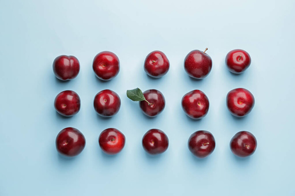 Fresh ripe plums on  color background - Фото, изображение