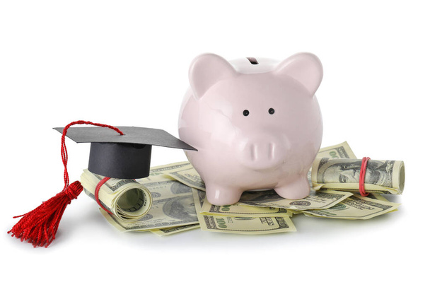Piggy bank with graduation hat and money on white background. Tuition fees concept - Photo, Image