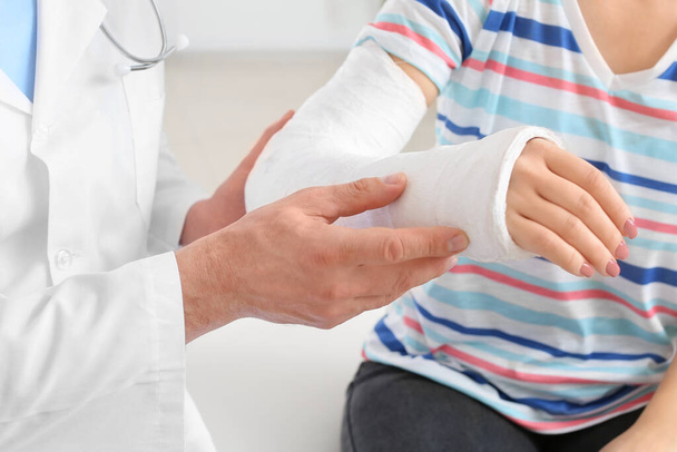 Junge Frau mit gebrochenem Arm besucht Arzt in Klinik - Foto, Bild
