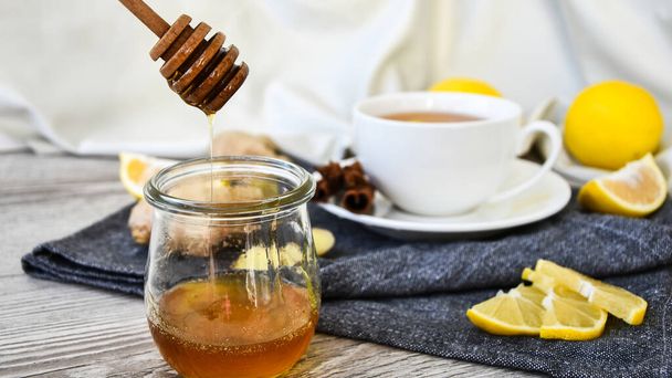Ginger hot immunity boosting Vitamin natural drink With citrus, honey and ingredients in a rustic style on wooden background. Chamomile tea. Healthy concept - 写真・画像