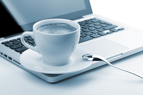 Cappuccino-kop op laptop. afgezwakt - Foto, afbeelding