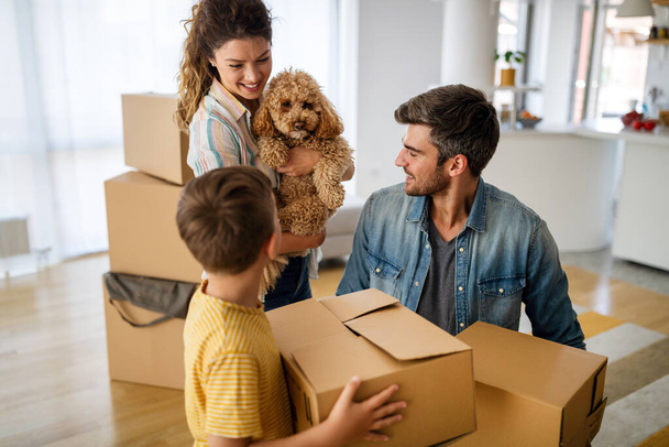 Husband and wife and their son with dog moving in new home. Family, relocation, moving in concept. - Фото, зображення