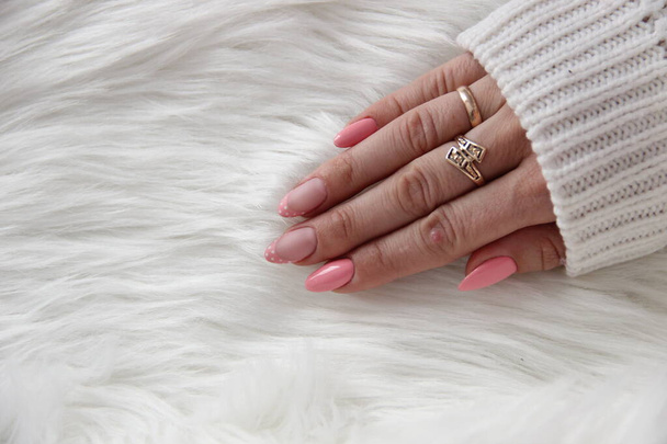 Hand met roze manicure. Twee nagels zijn polka - stip Frans met een matte afwerking, de rest is glanzend. - Foto, afbeelding