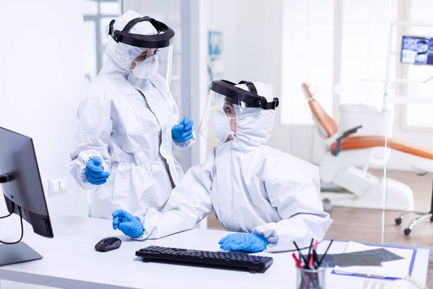 Dentist doctor in ppe suit discussing with nurse - Photo, Image