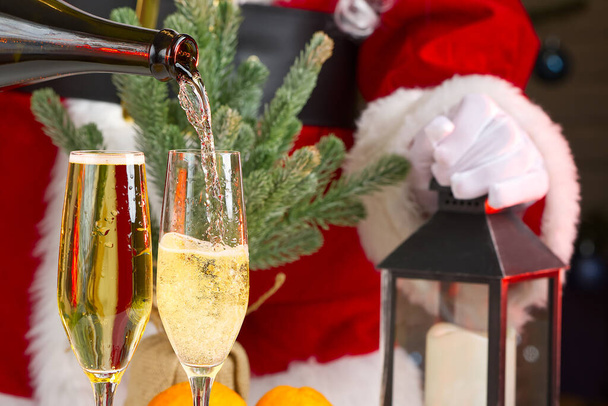 Babbo Natale vestito adulto versando champagne. versando spumante da calici, celebrazione, inizio vacanza, concetto di successo - Foto, immagini