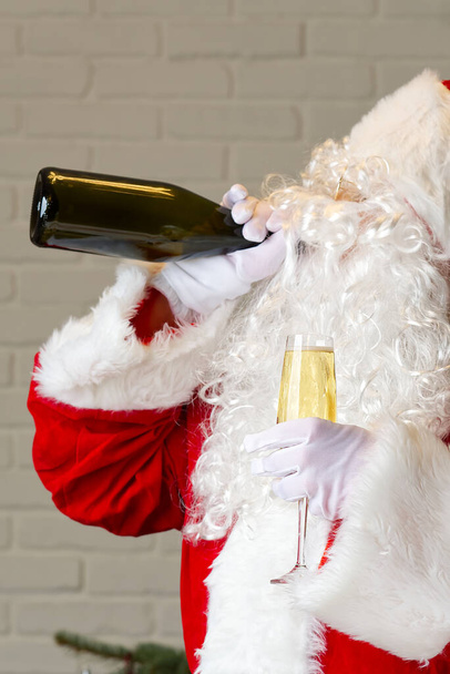 Santa Claus bebiendo vino espumoso de la botella. concepto de Santa Claus borracho - Foto, Imagen