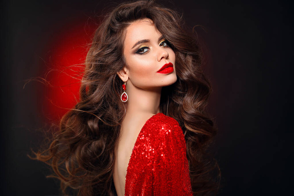 Beautiful sexy brunette in red dress with healthy curly hair and glamour makeup. Fashion Beauty Girl Isolated on black studio Background.  - Foto, Imagem