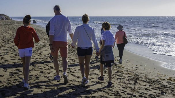 Μάλαγα, Ισπανία - 21 Δεκεμβρίου 2019: Happy Young Family Have Fun Walking On Beach Το χειμώνα - Φωτογραφία, εικόνα