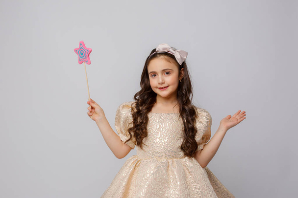 menina na imagem de uma fada com uma varinha mágica em um fundo branco - Foto, Imagem