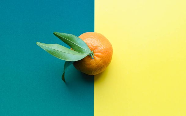 Fresh orange tangerine with green leaves isolated on colored background. Food levitation concept. Healthy food, ripe fruits, citrus fruits.copy space - Foto, imagen