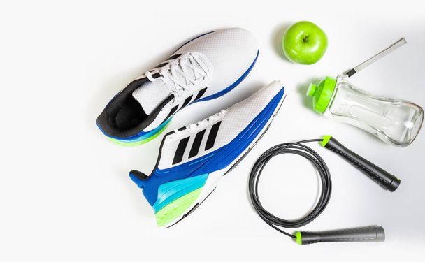 composition with jump rope green apple and a sport water bottle on white background - Foto, Imagem