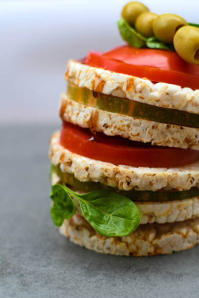 Rice cakes on a wooden background.Homemade healthy snacks rice crispbread with tomatoes, spinach and chopped vegetables.Light breakfast concept, healthy food - Φωτογραφία, εικόνα