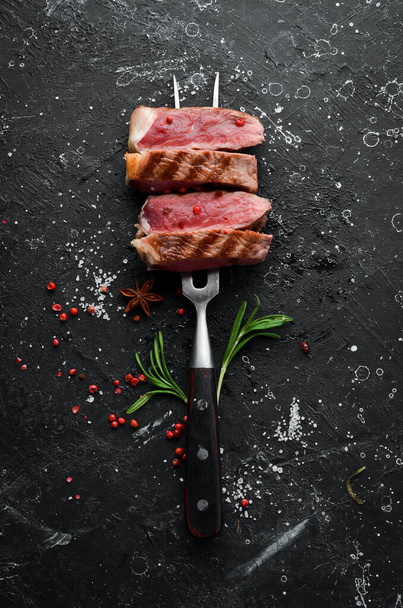 Grilled ribeye beef steak on the fork. Top view. Free space for your text. - Foto, Bild