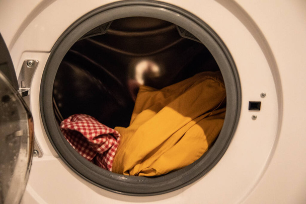 Waschmaschine wirbelt Wäsche vor Bullauge in Waschlösung - Foto, Bild