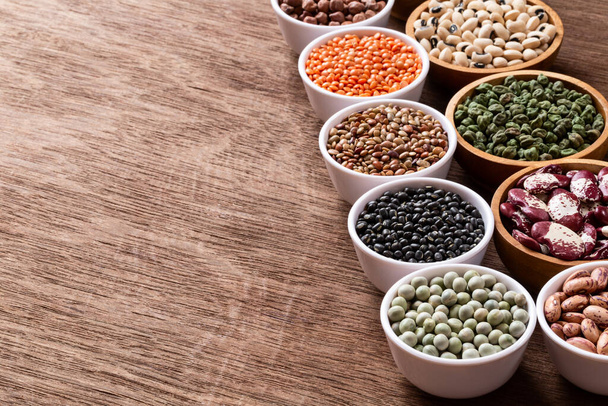 Various assortment set of indian legumes in bowls on wooden background with copyspace. Vegetable proteins. Protein products for vegans. Healthy eating concept. - Photo, Image