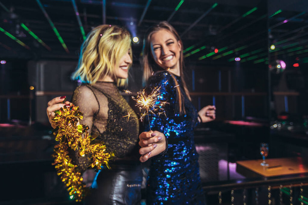 Meninas comemorando véspera de ano novo na boate. Grupo de amigas festejando no pub
 - Foto, Imagem
