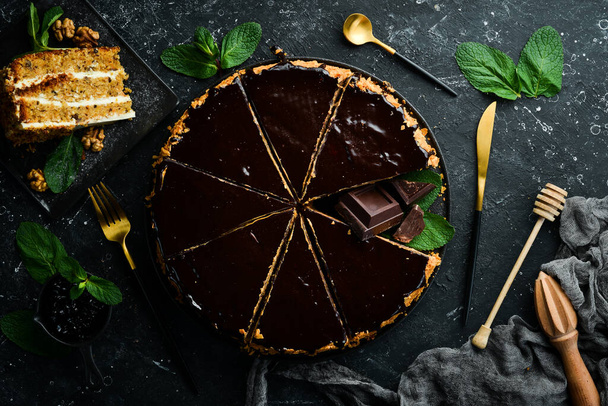 Delicious chocolate cake on a black stone plate. Top view. Rustic style. - 写真・画像