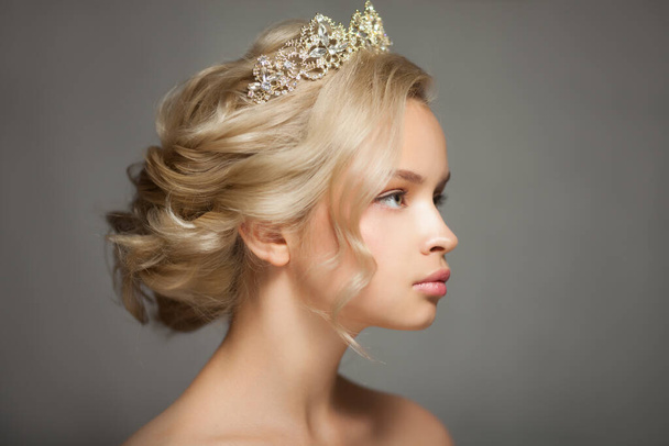 Beautiful blond woman in the image of a bride with a tiara in her hair. Picture taken in the studio on a gray background. Beauty baby face. Wedding image. - Fotó, kép