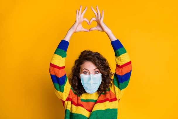 Photo of charming lady arms show heart crazy face wear respiratory striped sweater isolated yellow color background - Фото, изображение