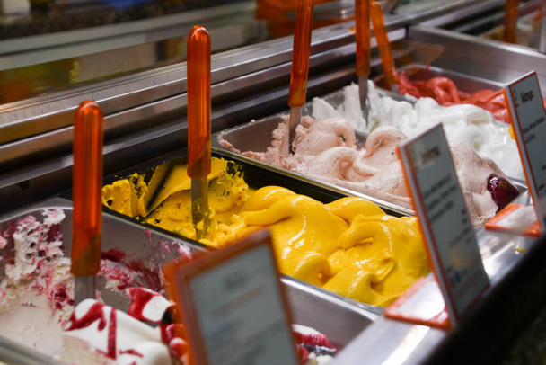 Dondurmanın farklı aromalı dondurmaları olan soğutmalı vitrin kapaklarını kapatın. - Fotoğraf, Görsel