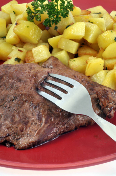 Hovězí steak s bramborami a petrželkou podávané na talíři detailní záběr na bílém pozadí  - Fotografie, Obrázek