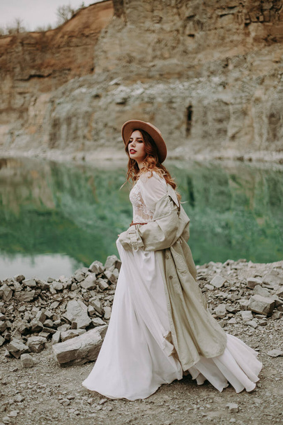 mooie jonge vrouw in wit jurk poseren bij meer - Foto, afbeelding