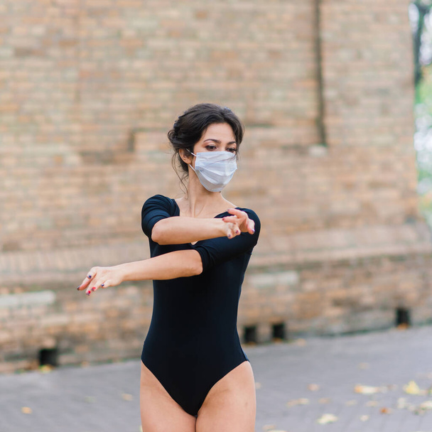 Yüz maskeli seksi bir kadının moda portresi ve sonbahar parkında bir vücut giysisi. Salgın, virüs, koronavirüs - Fotoğraf, Görsel