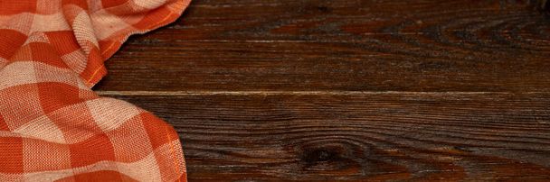 Kockás vászon terítő fából készült háttérrel. Barna fa asztal. Szelektív fókusz. Másold a helyet. Itt lehet enni és inni. Piknik és hálaadás napi koncepció - Fotó, kép