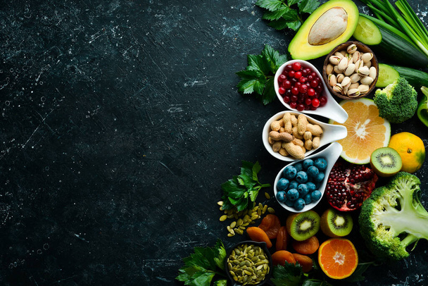 Healthy food. Vegetables and fruits. On a black wooden background. Top view. Copy space. - Foto, immagini